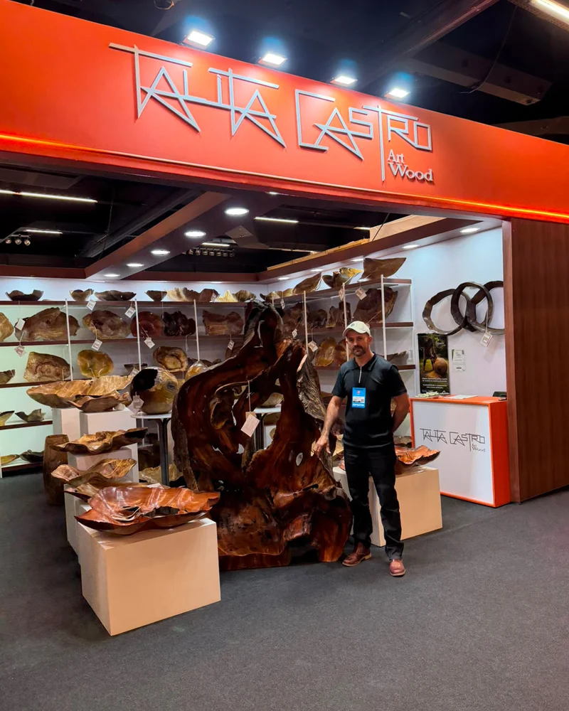 Alberto Palma no estande da Talita Castro Art Wood, ao lado de uma escultura de grande porte