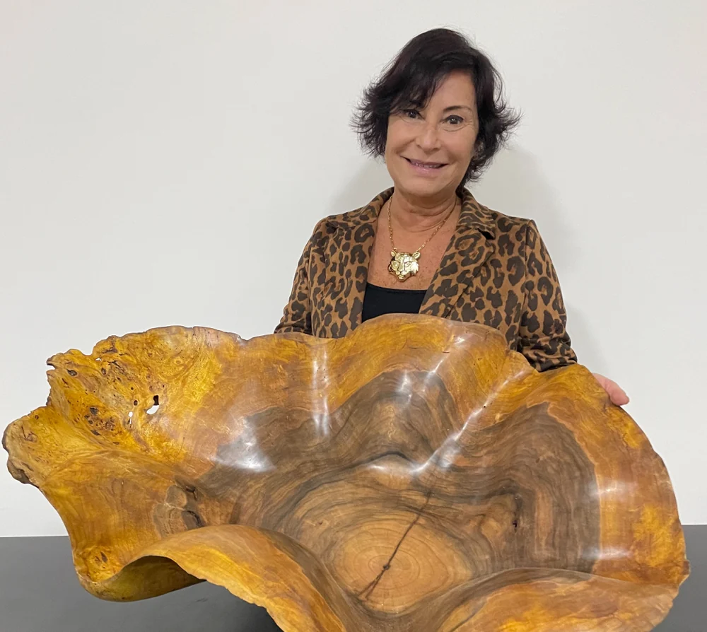 Talita Castro segurando um centro de mesa esculpido em madeira